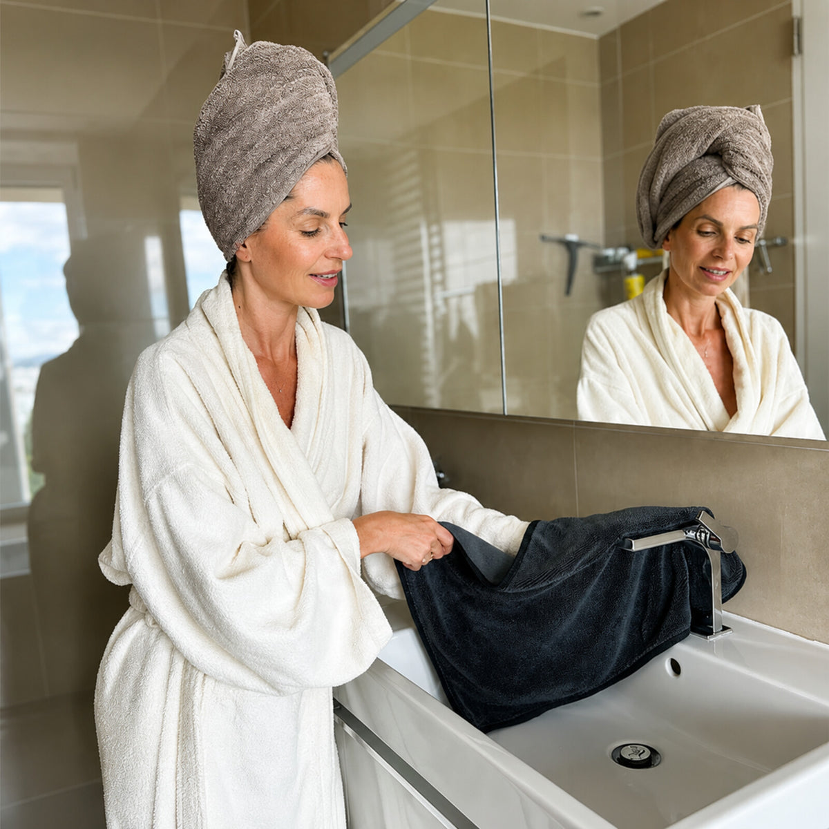 Femme utilisant le linge microfibre sur la robinetterie